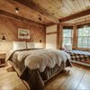 A cosy bedroom with sheepskin throw in a wood cabin Vrbo in Vermont