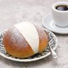 A maritozzo, or cream-filled roll, on a pretty patterned plate, with a double espresso