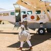 Jessica Nabongo carries a bag to the door of a small shuttle airplane in Tanzania