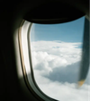 A view of fluffy clouds from an airplane window