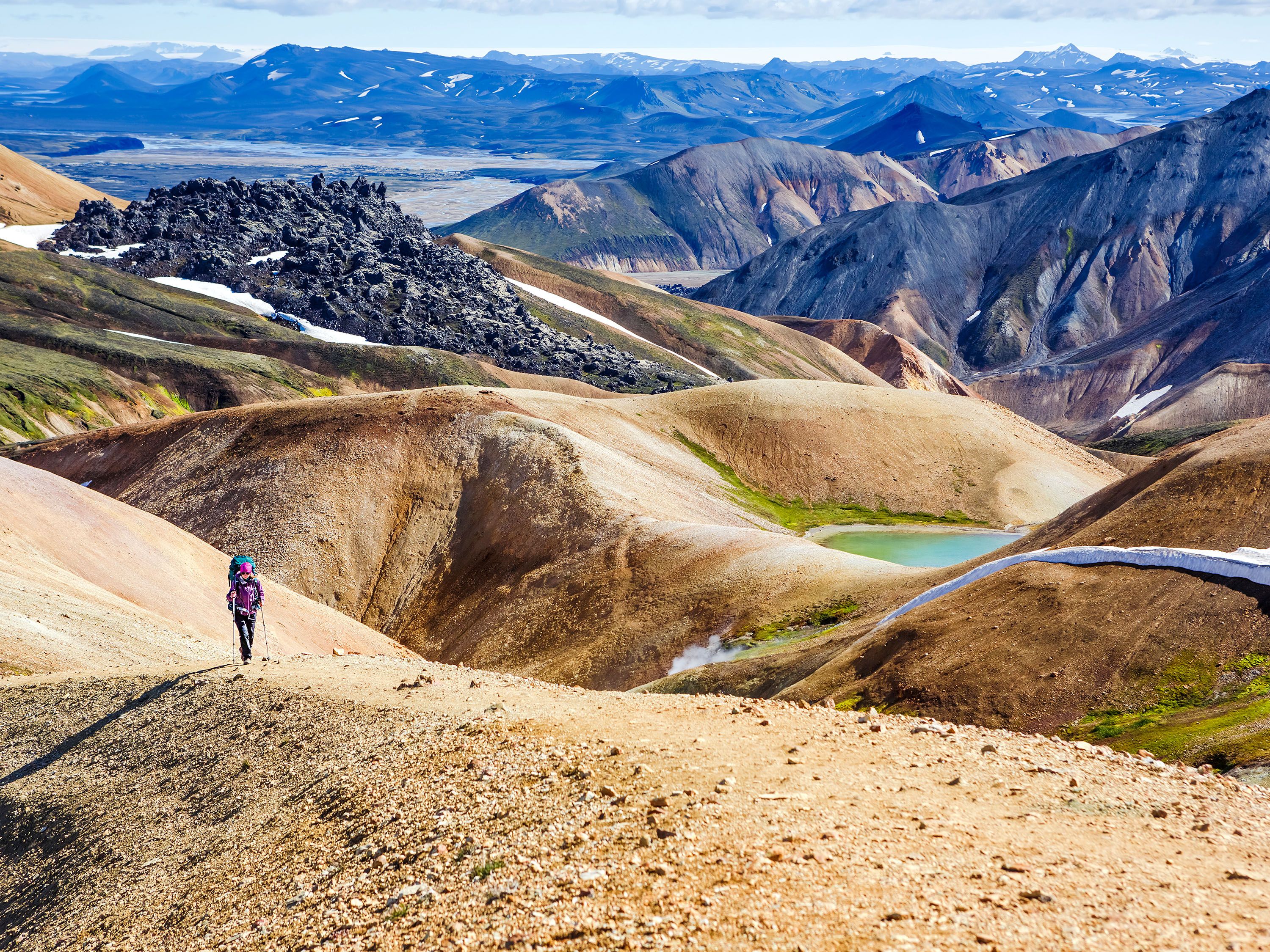 Woman hikes on rolling hills.