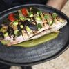 A whole fish is served over salsa verde with grilled vegetables at WILD Restaurant in Tulum, Mexico.