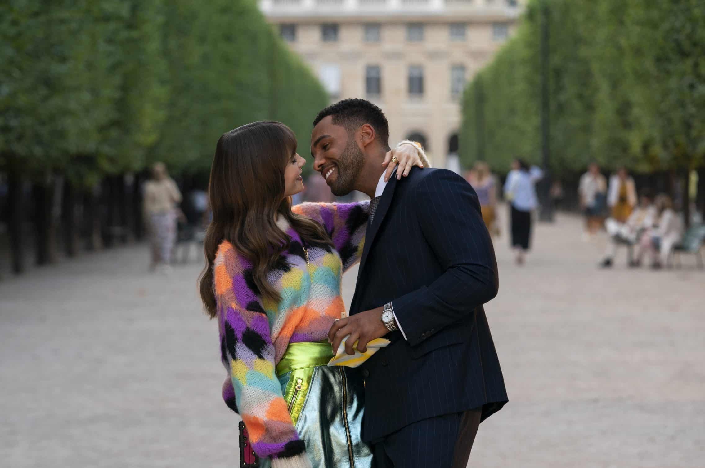 Lily Collins and Lucien Laviscount in an embrace in the Tuileries garden, in a scene for Emily in Paris