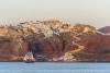 A boat sails around the island of Santorini