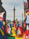 A sea of flags, including rainbow ones for Pride, heading towards Trafalgar Square, London