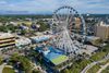 The SkyWheel Ferris wheel towering by the Myrtle Beach shoreline with buildings in the background.