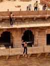 A young boy jumps from a balcony of the Toorji Ka Jhalra stepwell in Jodphur, India, to the water below