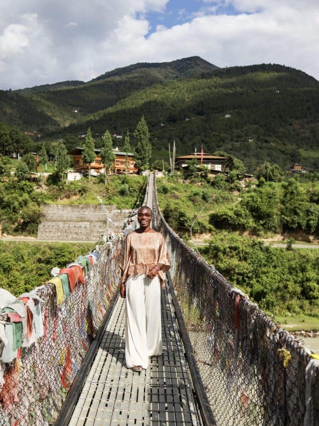 Jessica Nabongo walks across the suspension bridge in Punakha, Bhutan