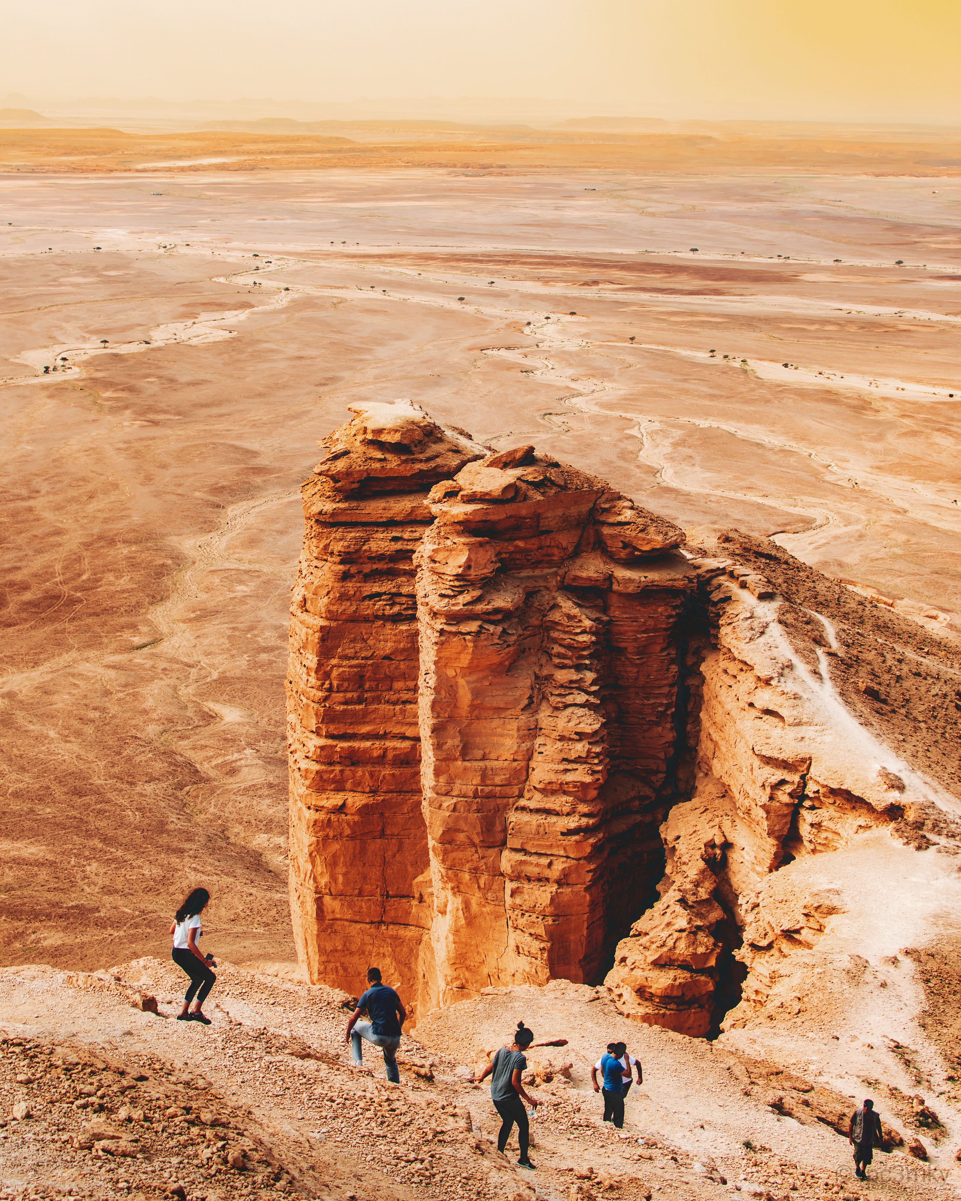 Towering sandstone cliffs stand sentinel over the wide-open landscape near Riyadh