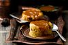 Date pudding with caramel on a plate with a spoon.