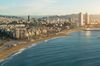 Aerial view of Barcelona Beach in the summer with the city skyline behind the Mediterranean Sea.