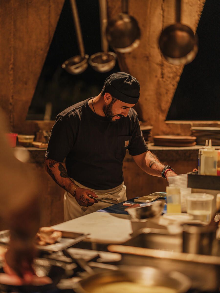 A chef in a black T-shirt and hat at work in the restaurant of the Paradero Todos Santos hotel