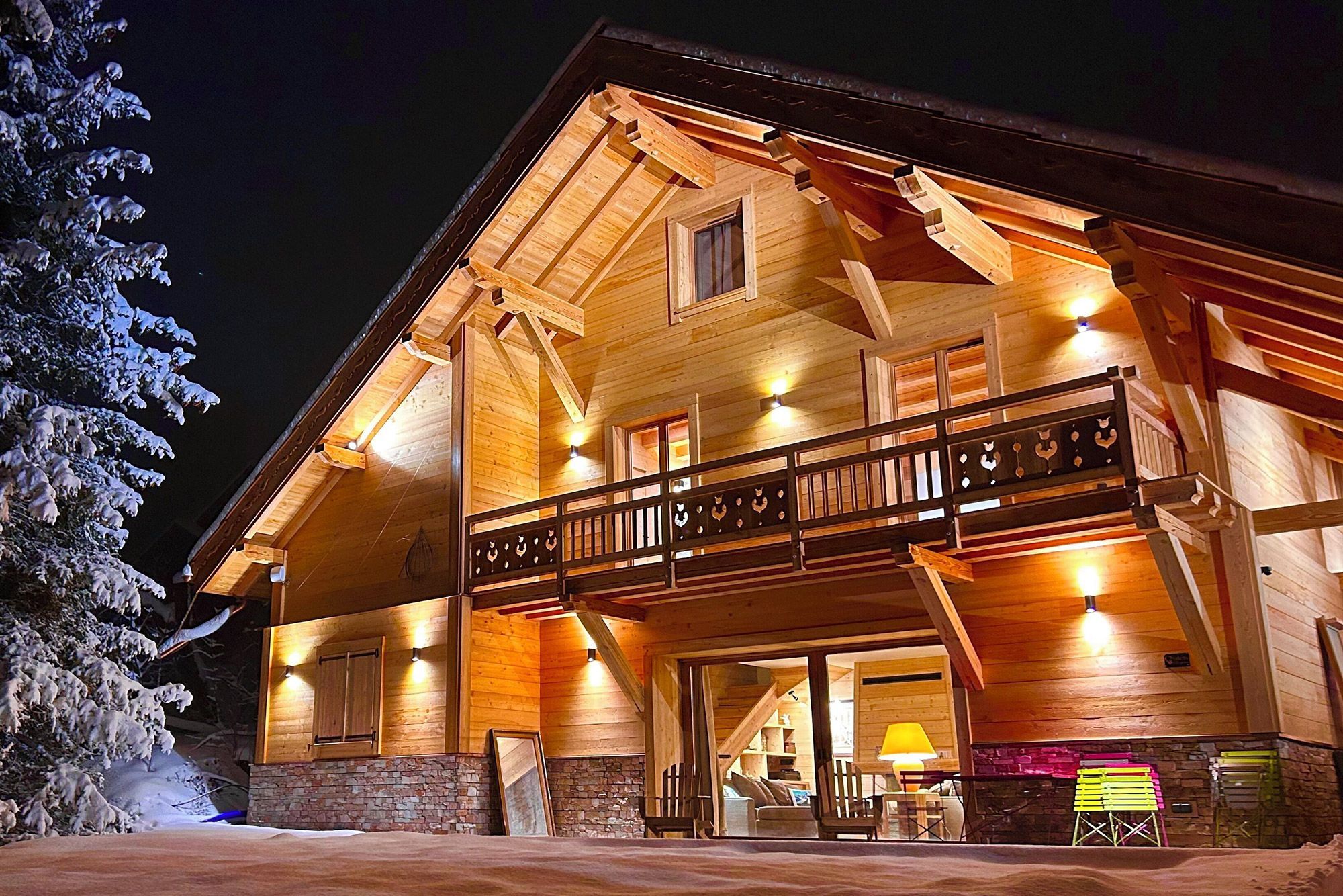 Grand chalet en bois éclairé de nuit, au style cosy, à Serre-Chevalier dans les Hautes-Alpes, disponible sur Abritel