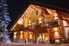 Grand chalet en bois éclairé de nuit, au style cosy, à Serre-Chevalier dans les Hautes-Alpes, disponible sur Abritel
