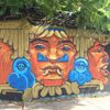 A colorful mural featuring warrior faces by Apitatán. (Image courtesy of meetingofstyles.com)