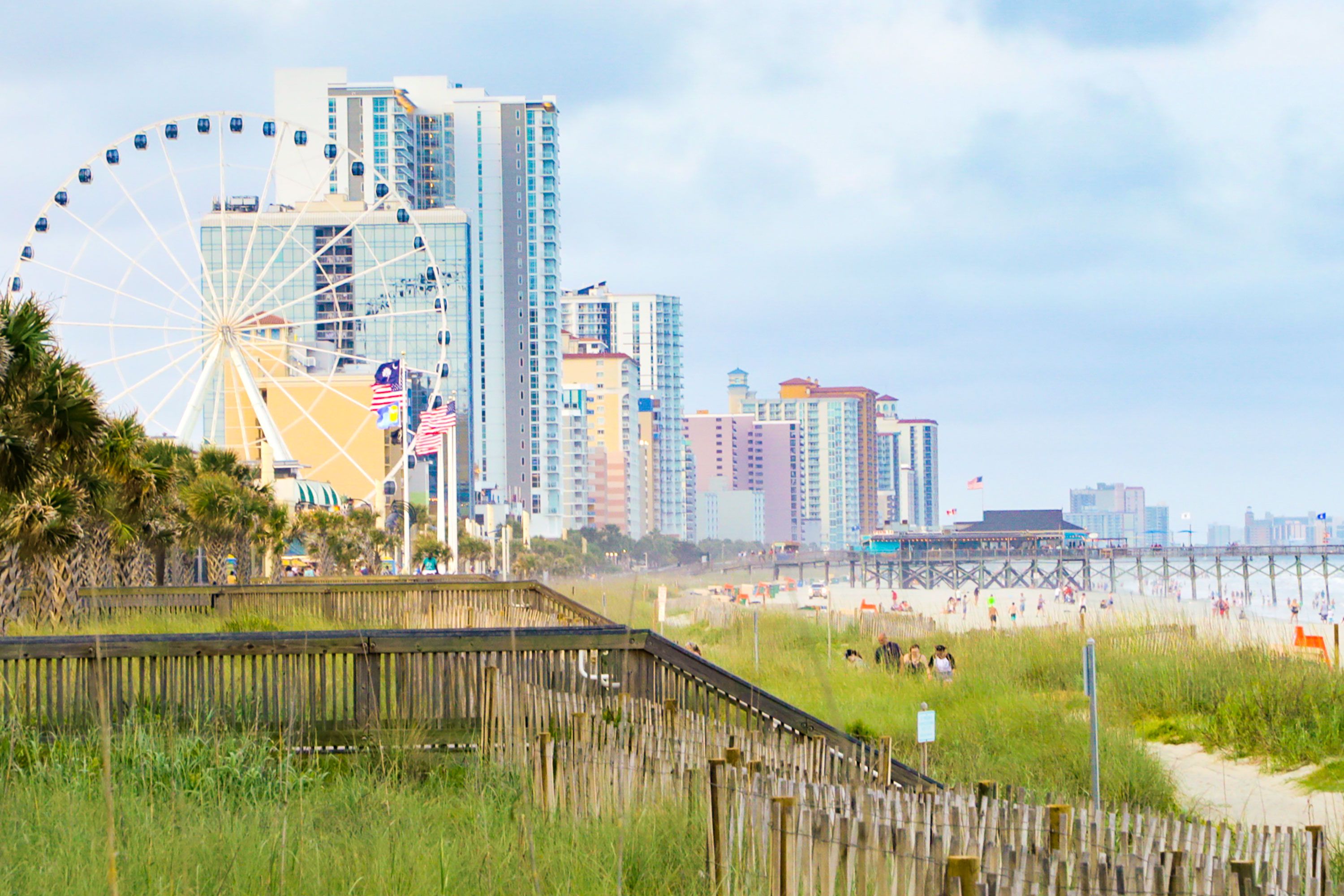 The Myrtle Beach SkyWheel stands beside beachfront hotels and a boardwalk along the coast.