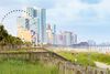 The Myrtle Beach SkyWheel stands beside beachfront hotels and a boardwalk along the coast.