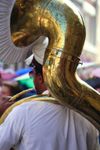 A musician wearing a peaked hat plays a sousaphone, a brass instrument in the tuba family, in New Orleans