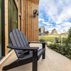 An Adirondack chair on the veranda of a wood A-frame cabin Vrbo in Texas