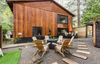 The exterior of a wooden chalet-style Vrbo rental with outdoor seating around a firepit in Rhododendron, Oregon