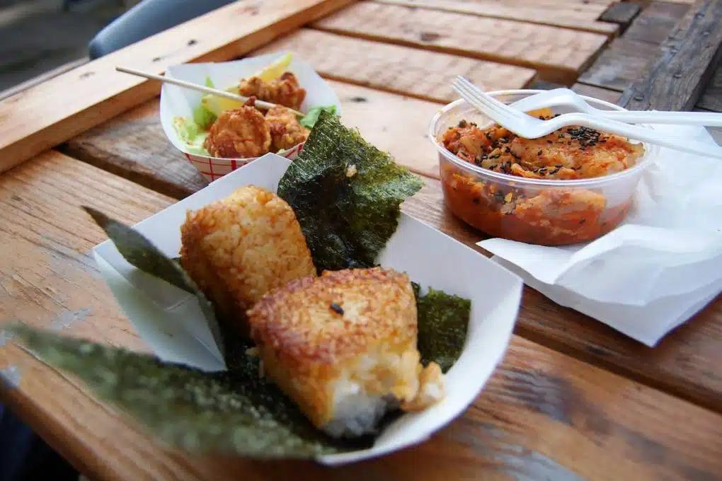 Yaki onigiri, kimchi and fried chicken are served street-food style in takeout boxes