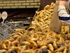 Piles of fresh bagels come out of a wood-fire oven.