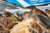 Two people hiking on the colorful Kerlingarfjöll mountain range in Iceland.