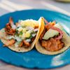 Soft tacos served on a bright blue plate