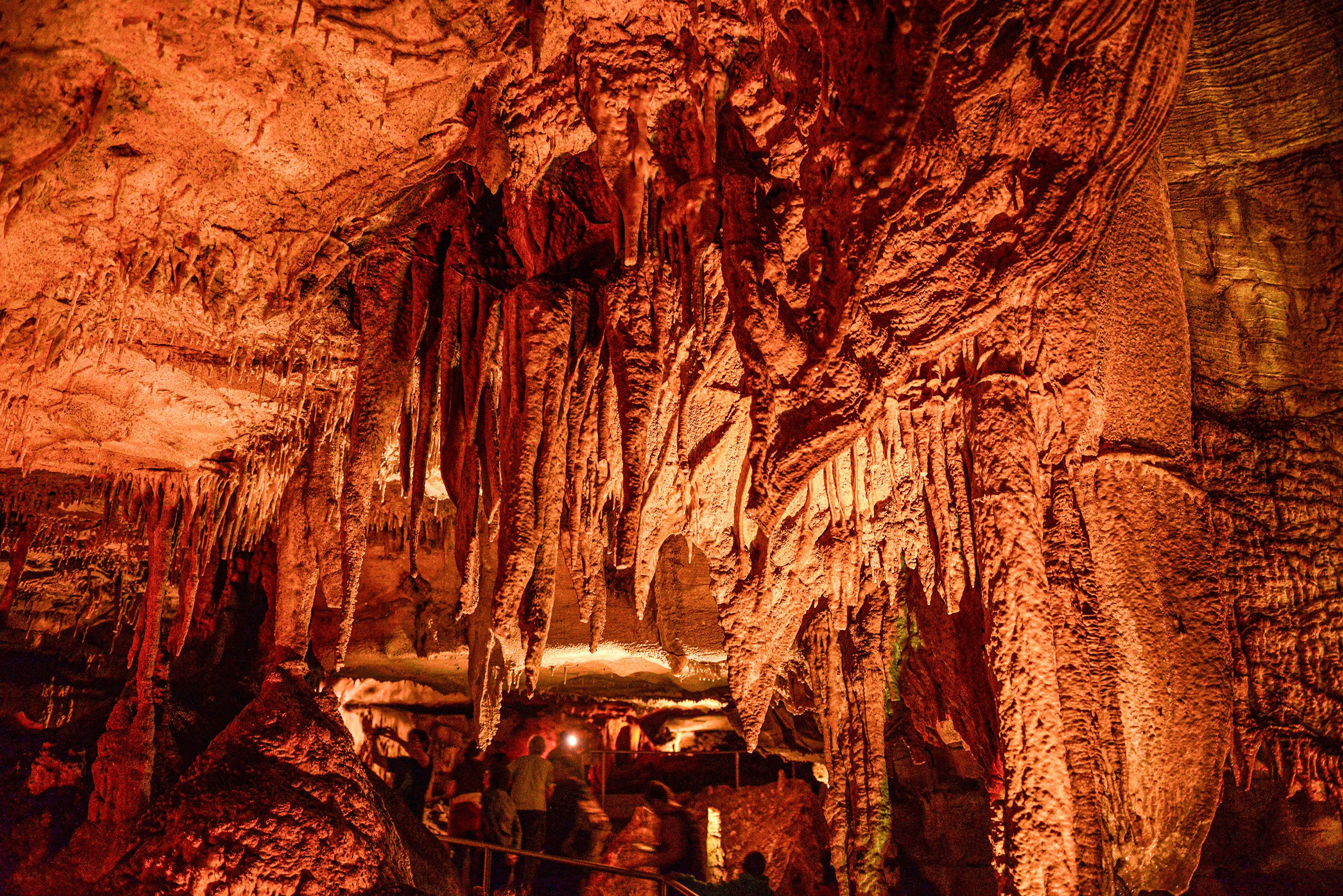 Stalagtites hang from ceiling in cave.