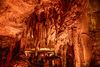 Stalagtites hang from ceiling in cave.