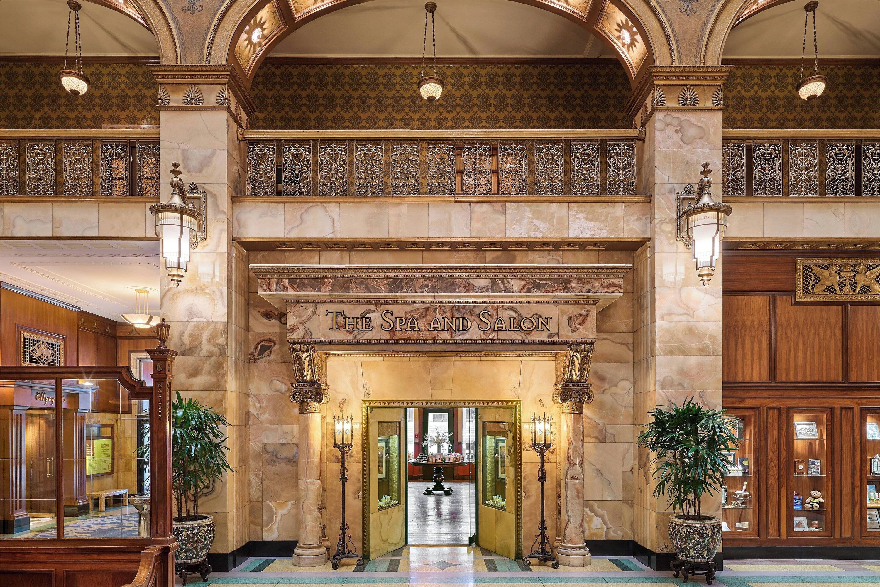 A grand marble entrance to an elegant spa and salon with ornate architectural details.