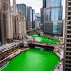 A river dyed bright green downtown a city.