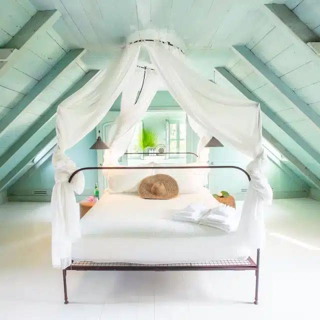 The attic bedroom, with mint-green walls and glossy white floor