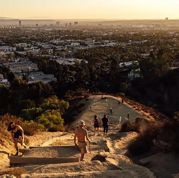 View of Los Angeles and people hiking up Runyon Canyon Trail