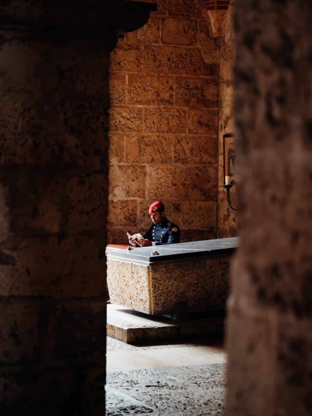 A museum guard reads a book at a desk; the city is home to myriad historical and cultural institutions