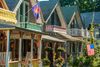 Colorful Victorian-era gingerbread cottages in Oak Bluffs, Martha’s Vineyard, with ornate wooden trim and pastel paint, lined up along a quiet street.