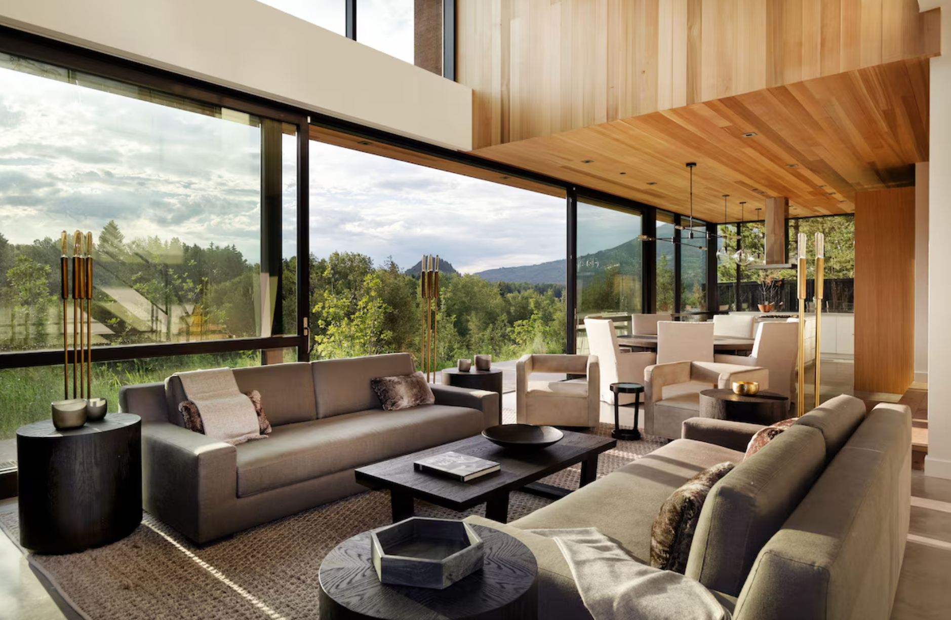 The open-plan living space with sliding floor-to-ceiling doors overlooking the trees at a luxury Vrbo rental property in Aspen, Colorado 