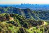 The iconic Griffith Observatory can be see amid the lush Hollywood Hills with Downtown Los Angeles in the background.