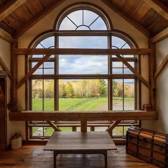 Light pours in through the arched windows of the master bedroom of a Vermont Vrbo