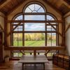 Light pours in through the arched windows of the master bedroom of a Vermont Vrbo
