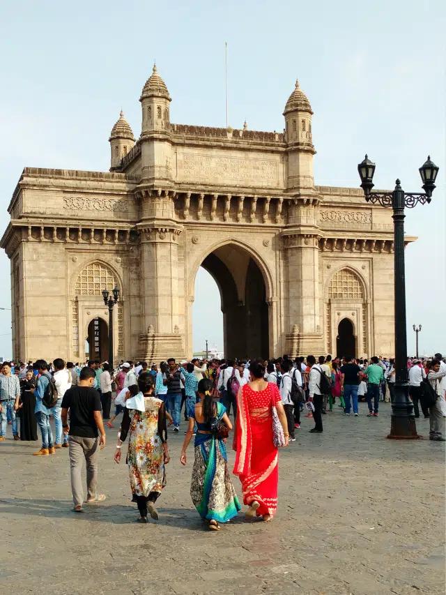 Groups of people visit the 85-foot Gateway of India arch in Mumbai, India