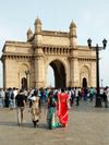 Groups of people visit the 85-foot Gateway of India arch in Mumbai, India