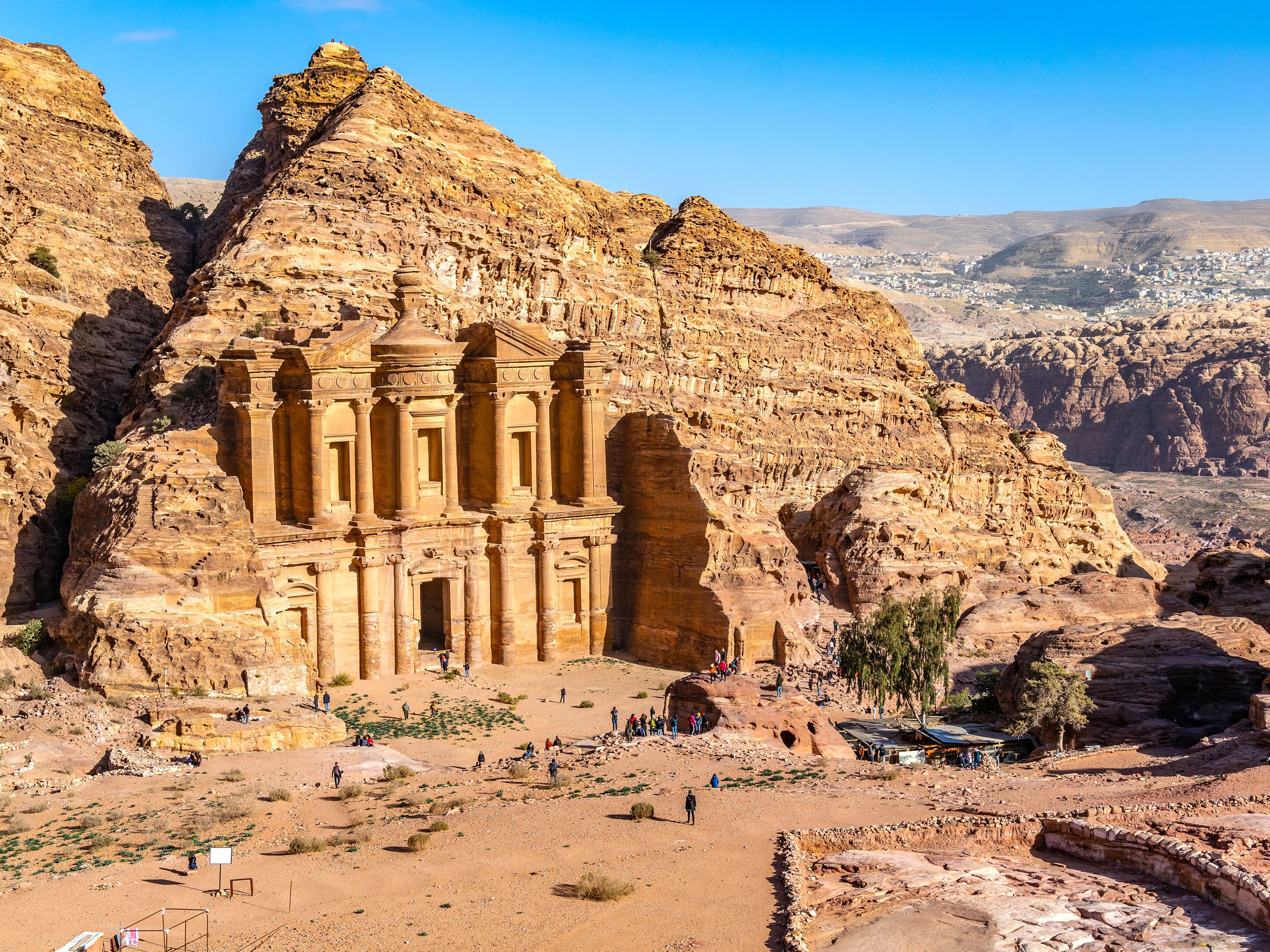 Sand-colored building carved out of a mountain.