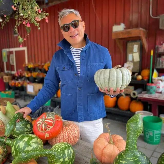 William Li in Great Barrington, Massachusetts, with a display of colorful pumpkins outside a store