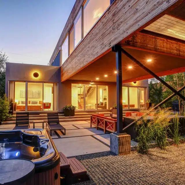 The garden area and hot tub of a mid-century Vrbo rental chalet in Winter Park, Colorado 