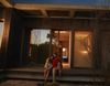 A couple sits on the steps of a home as sun sets
