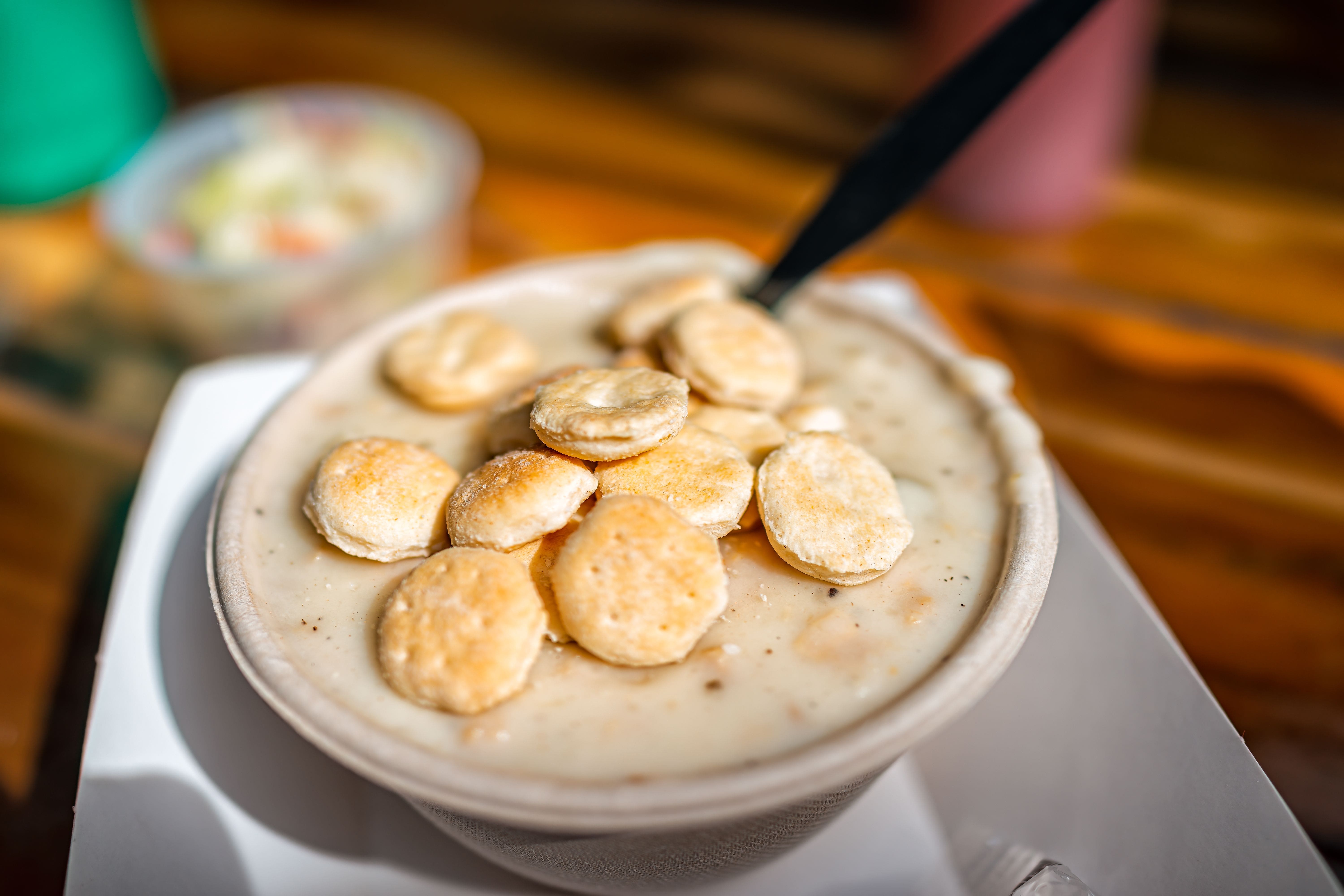 A bowl of New England-style clam chowder topped with oyster crackers