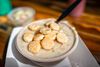 A bowl of New England-style clam chowder topped with oyster crackers