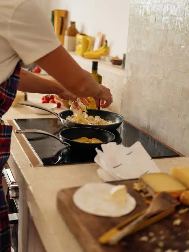 A close up of a person cooking at a stove