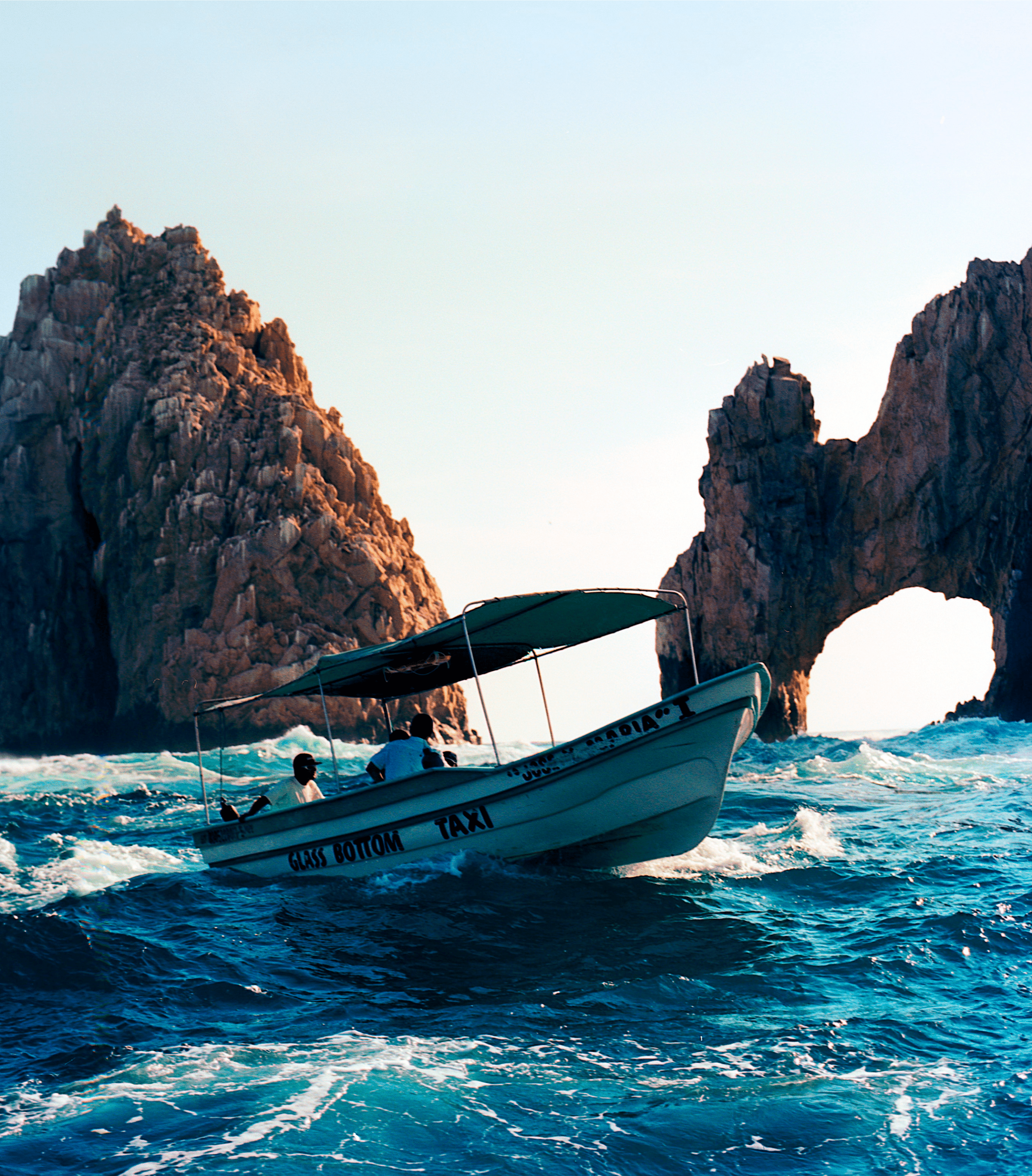 A sightseeing boat sails past the Cabo Arch in Los Cabos